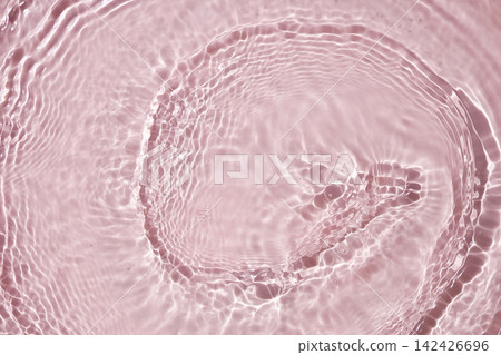 Clear water ripples and bright reflections on a light pink surface. Clear water ripples and bright reflections on a light pink surface. 142426696