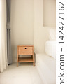 Wooden Bedside Table Beside a Bed 142427162