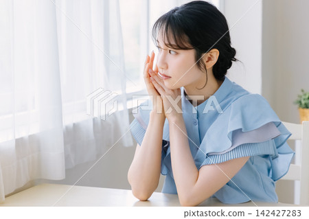 在房間裡思考的年輕女人 在房間裡思考的年輕女人 142427283