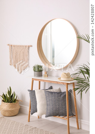 Round mirror and wooden table at home. Idea for interior design Round mirror and wooden table at home. Idea for interior design 142428807