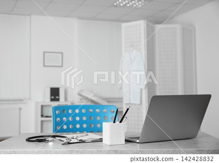 Doctor's workplace with laptop in modern clinic Doctor's workplace with laptop in modern clinic 142428832
