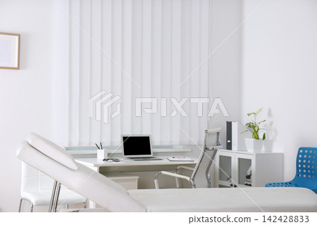 Doctor's office interior with desk and examination couch Doctor's office interior with desk and examination couch 142428833