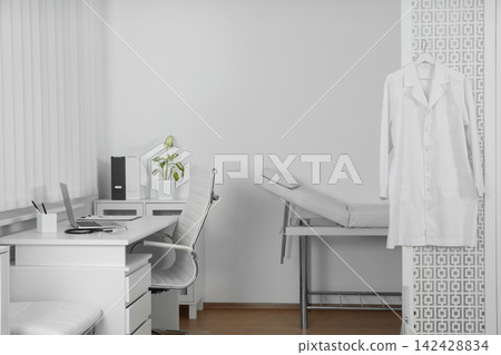 Doctor's office interior with desk and examination couch Doctor's office interior with desk and examination couch 142428834