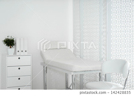 Examination room with modern couch and folding screen in clinic Examination room with modern couch and folding screen in clinic 142428835