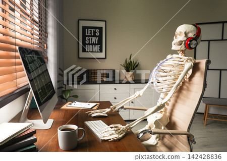 Human skeleton with headphones using computer at workplace Human skeleton with headphones using computer at workplace 142428836