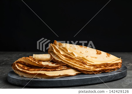 Delicious fresh thin pancakes on grey table Delicious fresh thin pancakes on grey table 142429126