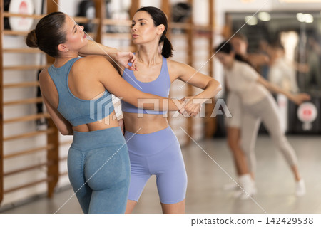 Young girl practicing self-defense techniques in pair Young girl practicing self-defense techniques in pair 142429538