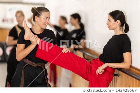 Woman Helps Stretch Another Woman 142429567