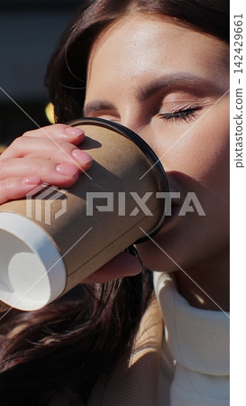 Vertical video. Closeup of a woman enjoying her take away coffee. Vertical video. Closeup of a woman enjoying her take away coffee. 142429661