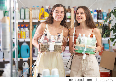 Girls friends choose liquid detergent in household shop Girls friends choose liquid detergent in household shop 142429889