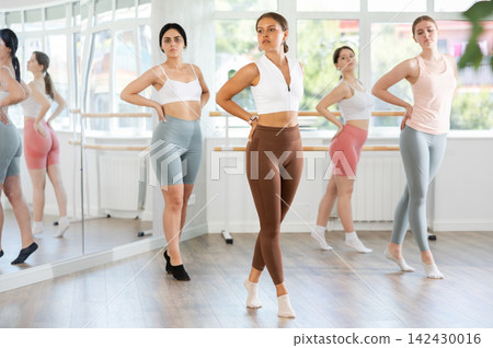 Young girl executing ballet moves during group rehearsal Young girl executing ballet moves during group rehearsal 142430016