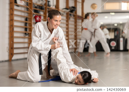Women athletes in pair conduct training battle in oriental fighting technique judo Women athletes in pair conduct training battle in oriental fighting technique judo 142430069