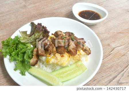 grilled pork dipping spicy chili tamarind Thai sauce with fried cream egg omelet and vegetable salad on rice in plate grilled pork dipping spicy chili tamarind Thai sauce with fried cream egg omelet and vegetable salad on rice in plate 142430717