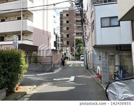 在陽光明媚的日子裡,東京狹窄的街道兩旁是房屋,構成了一幅美麗的城市景觀。 在陽光明媚的日子裡,東京狹窄的街道兩旁是房屋,構成了一幅美麗的城市景觀。 142430935