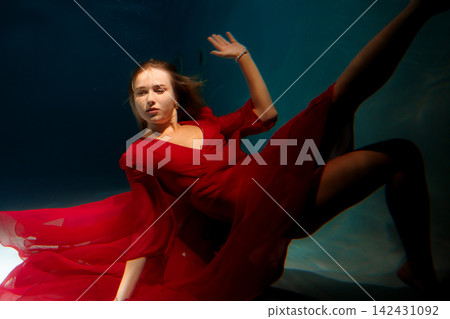 Enchanting underwater siren with flowing fabric and hypnotic gaze Enchanting underwater siren with flowing fabric and hypnotic gaze 142431092