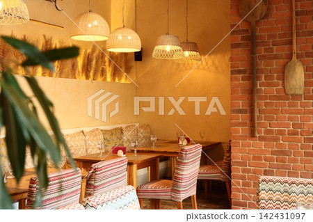 Charming cafe corner with soft lighting and plush cushions Charming cafe corner with soft lighting and plush cushions 142431097