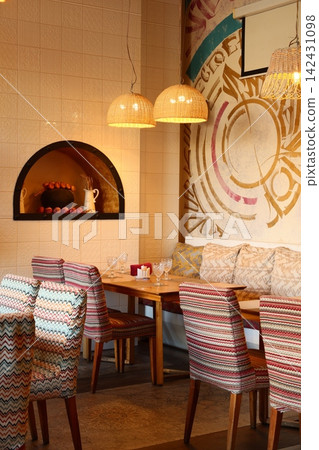Eclectic seating space accented by warm lighting and textured decor Eclectic seating space accented by warm lighting and textured decor 142431098