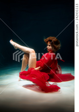 Vibrant female figure dancing underwater with flowing fabric Vibrant female figure dancing underwater with flowing fabric 142431113