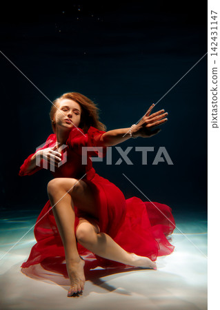 Caucasian actress underwater in red dress, expressive performance Caucasian actress underwater in red dress, expressive performance 142431147