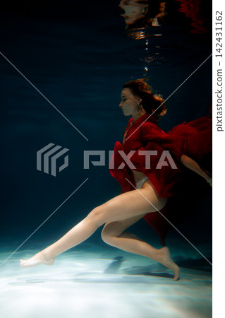 Underwater scene featuring bold dress and dramatic lighting effects Underwater scene featuring bold dress and dramatic lighting effects 142431162