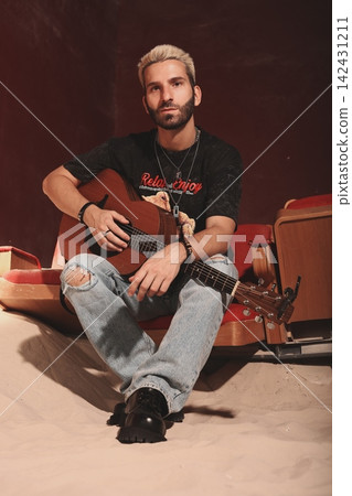 Man resting peacefully. Man in ripped jeans enjoys quiet moment Man resting peacefully. Man in ripped jeans enjoys quiet moment 142431211