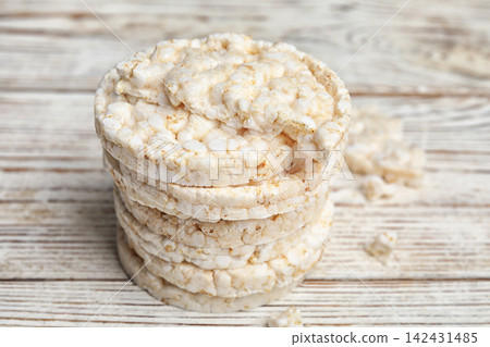 Stack of puffed rice cakes on white wooden table Stack of puffed rice cakes on white wooden table 142431485