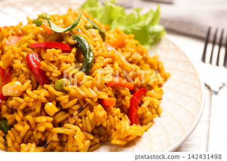 Delicious rice pilaf with vegetables on white table, closeup Delicious rice pilaf with vegetables on white table, closeup 142431498