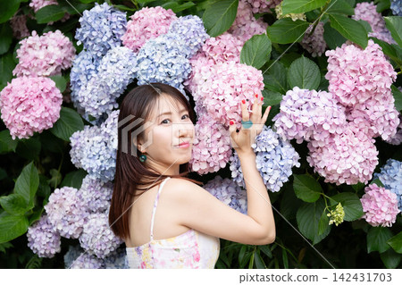 一位年輕女子正在撫摸繡球花 一位年輕女子正在撫摸繡球花 142431703