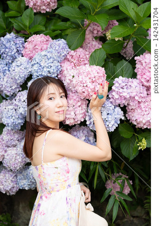 一個被繡球花包圍的年輕女子 一個被繡球花包圍的年輕女子 142431704