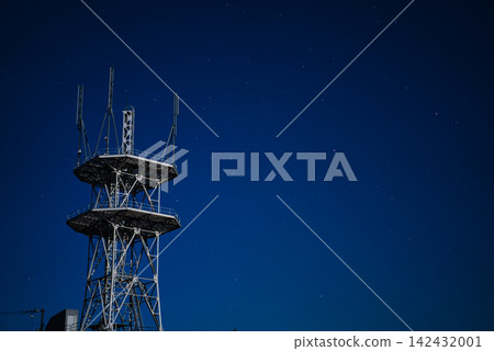 A night view of a large communications tower soaring against a starry sky. A night view of a large communications tower soaring against a starry sky. 142432001