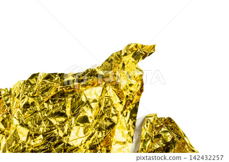 Close-up of crumpled shiny gold foil texture isolated on a white background. Holiday or celebration background Close-up of crumpled shiny gold foil texture isolated on a white background. Holiday or celebration background 142432257