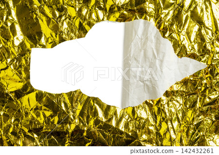 Crumpled gold foil sheet with a torn hole revealing textured white paper and blank white copyspace. Holiday, celebration or texture background 142432261