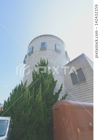 一棟圓形建築和綠樹映襯著藍天。 142432359