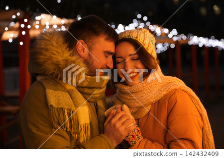 Happy couple spending time at Christmas fair Happy couple spending time at Christmas fair 142432409