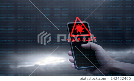 A hand holding a smartphone showing a red 'VIRUS ALERT' warning icon, set against a dark background with digital binary code. Concept of Technology Security A hand holding a smartphone showing a red 'VIRUS ALERT' warning icon, set against a dark background with digital binary code. Concept of Technology Security 142432460