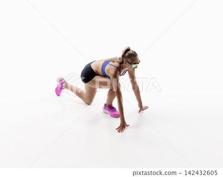 Low sprint start showing female athlete pushing forward from crouched position Low sprint start showing female athlete pushing forward from crouched position 142432605