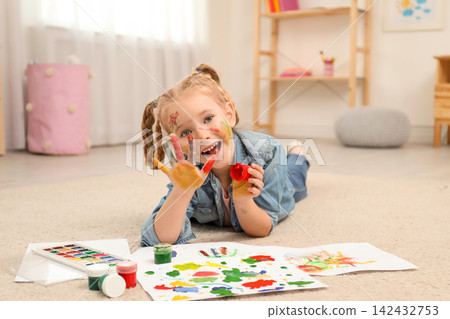 Cute little child painting with palms at home 142432753