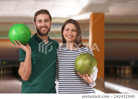 Young couple with balls in bowling club 142432840