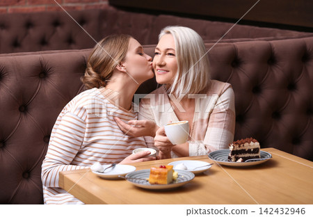Mother and her adult daughter spending time together in cafe Mother and her adult daughter spending time together in cafe 142432946