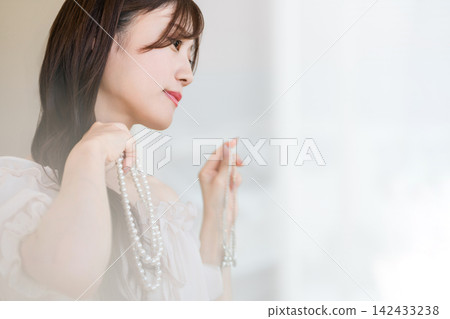 一位佩戴珍珠項鍊的年輕亞洲女性。 一位佩戴珍珠項鍊的年輕亞洲女性。 142433238