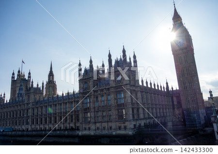 Westminster Palace in the heart of London, bathed in the dazzling backlight of the Thames River. Westminster Palace in the heart of London, bathed in the dazzling backlight of the Thames River. 142433300