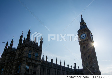 Westminster Palace in the heart of London, bathed in the dazzling backlight of the Thames River. Westminster Palace in the heart of London, bathed in the dazzling backlight of the Thames River. 142433303