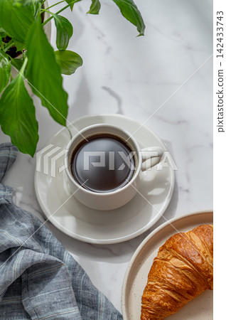 Cup of freshly espresso coffee and fresh croissant on a marble background Cup of freshly espresso coffee and fresh croissant on a marble background 142433743
