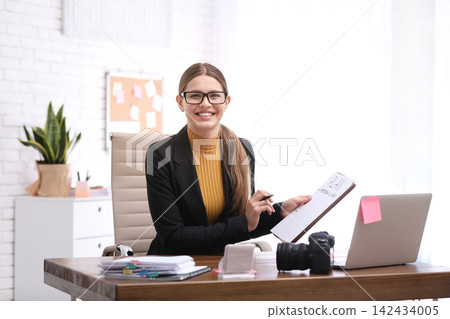 Young journalist working at table in office Young journalist working at table in office 142434005