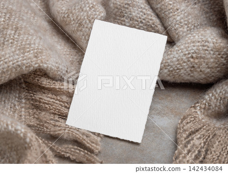 Blank card mockup on grey stone and beige blanket, copy space. Minimal rustic stationery template Blank card mockup on grey stone and beige blanket, copy space. Minimal rustic stationery template 142434084