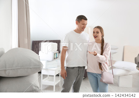 Woman holding cup of delicious hot cocoa with marshmallows at white table indoors, closeup 142434142