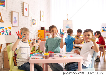 Cute little children with painted palms in room Cute little children with painted palms in room 142434177