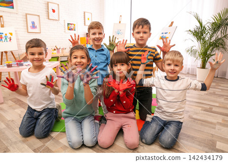 Cute little children with painted palms in room Cute little children with painted palms in room 142434179