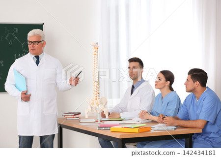 Medical students and professor studying human spine structure in classroom 142434181