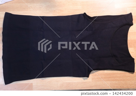 Black Sleeveless Top on Wooden Surface Black Sleeveless Top on Wooden Surface 142434200